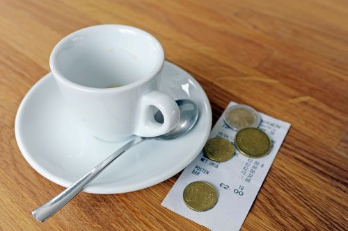 Foto: Kaffeetasse mit Rechnung und Münzen